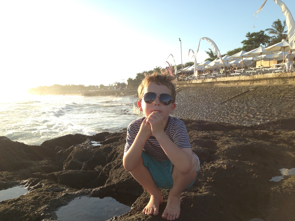 Oskar sidder på klippen foran restauranten på Echo Beach