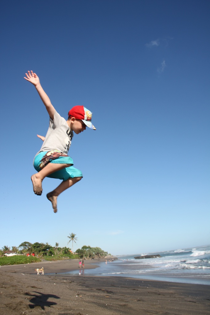 Oskar hopper på stranden mellem Batu Bolong og Echo Beach